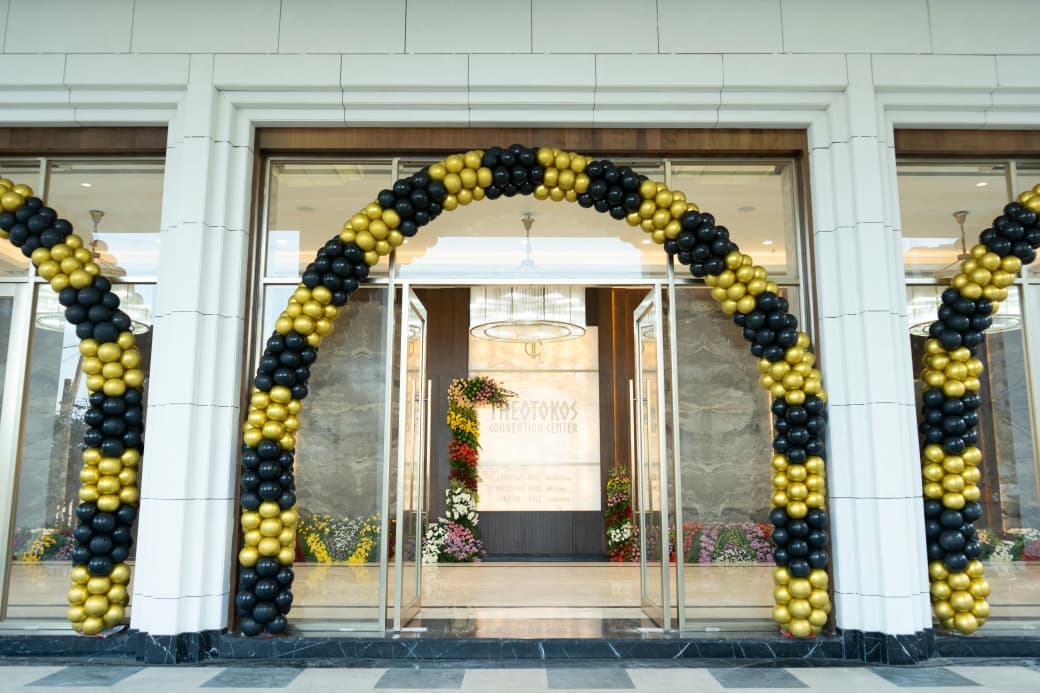 Black and gold balloon arch framing the glass entrance doors on inauguration day