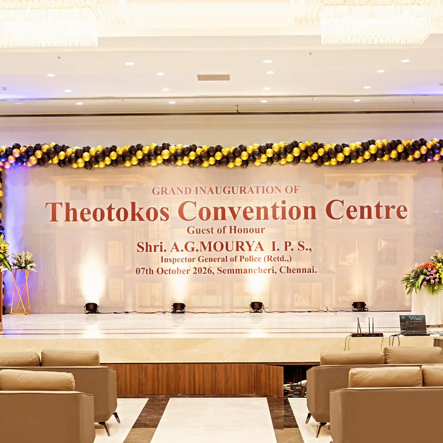 Stage banner reading Grand Inauguration of Theotokos Convention Centre, 7th October 2026, under a black and gold balloon garland