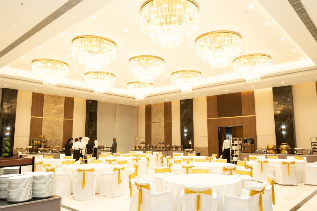Dining hall under round crystal chandeliers, with buffet counters along the far wall