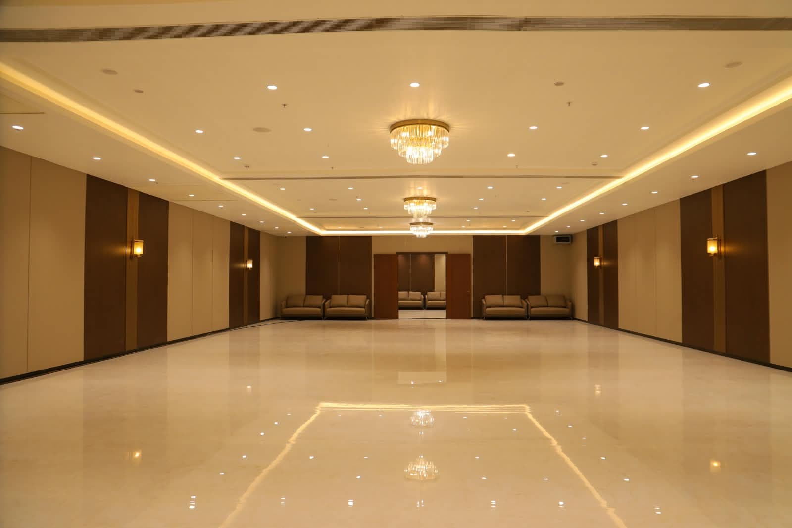 Christos party hall with lounge seating at the far end beneath tiered chandeliers