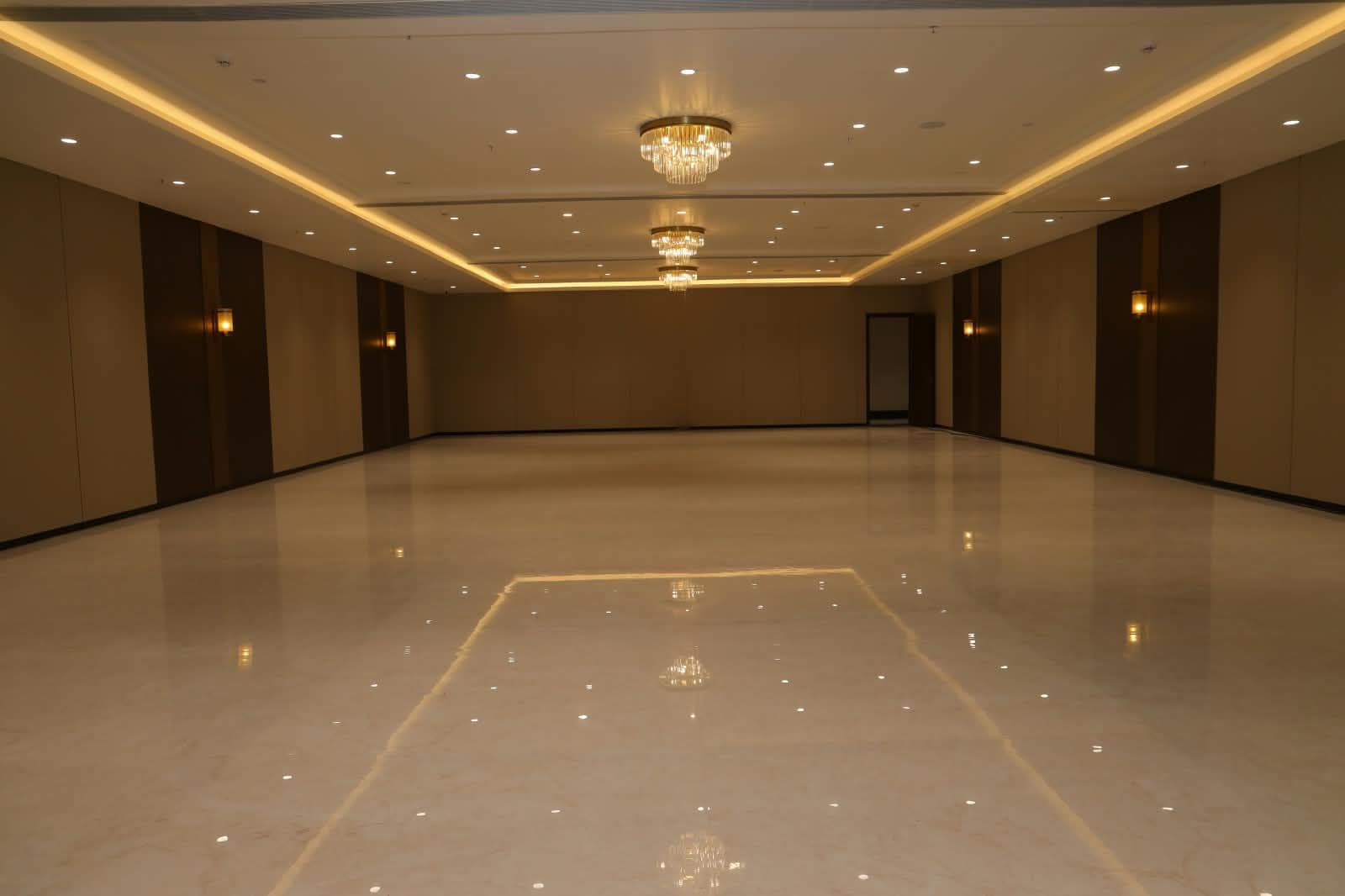 Chandeliers receding down the length of Christos hall above a mirror-polished floor