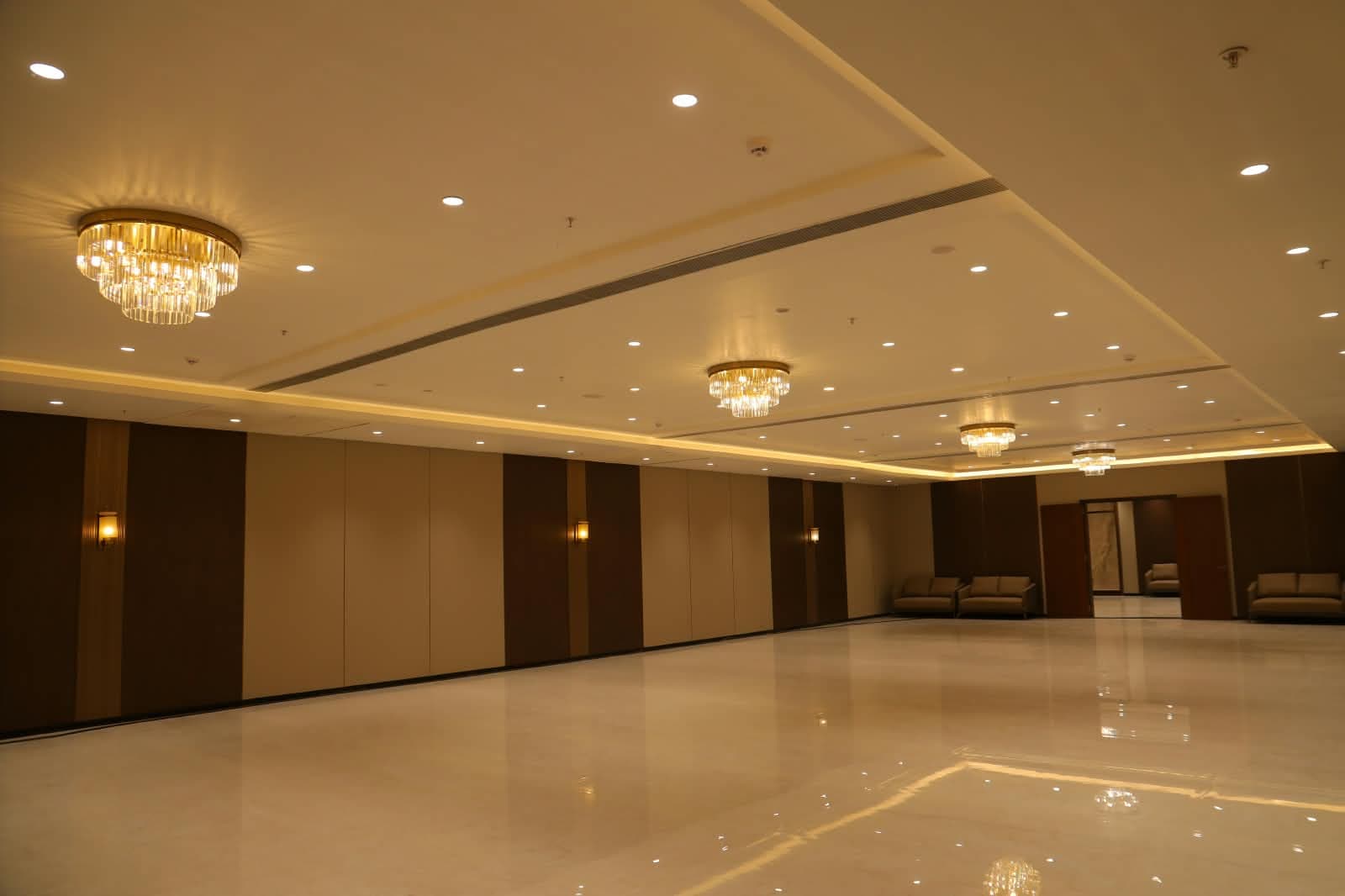 Christos hall seen at an angle, its panelled movable partitions lit by wall sconces