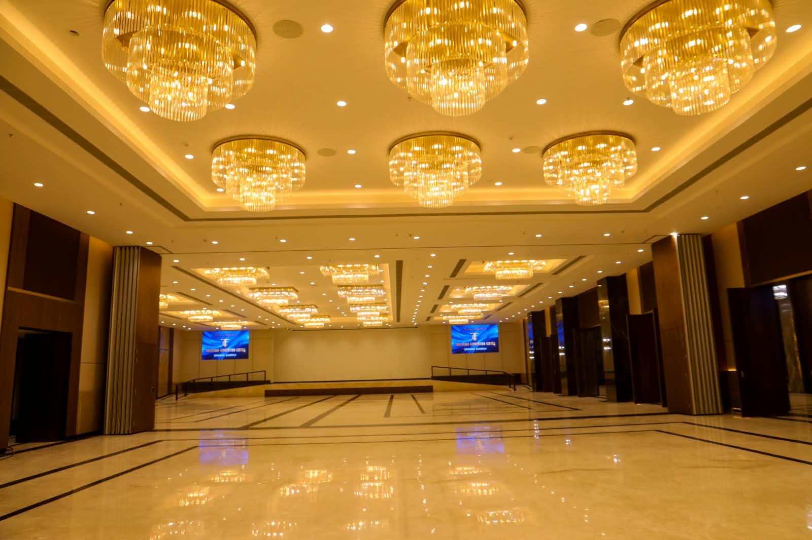 Round tiered chandeliers over the polished marble floor of Dominikos hall