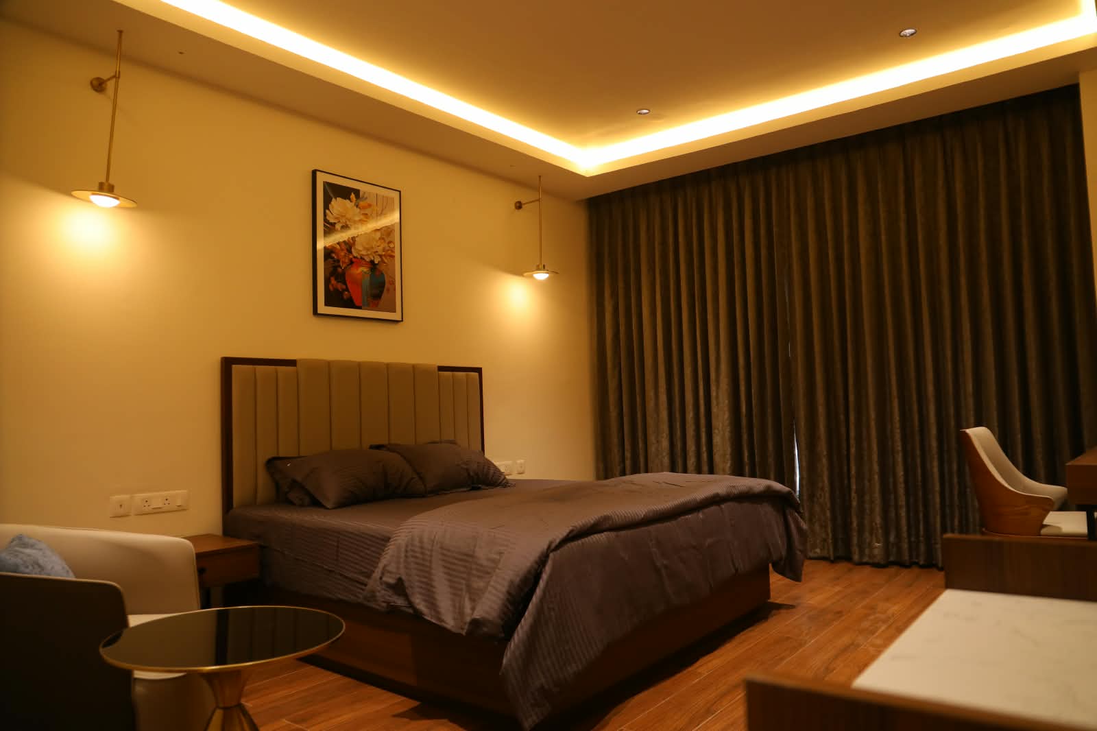 Guest room with a double bed, reading lamps and floor-length curtains