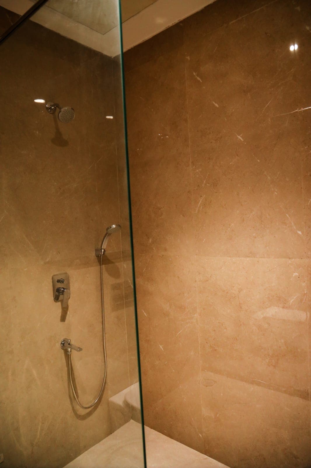 Glass-screened shower enclosure finished in stone
